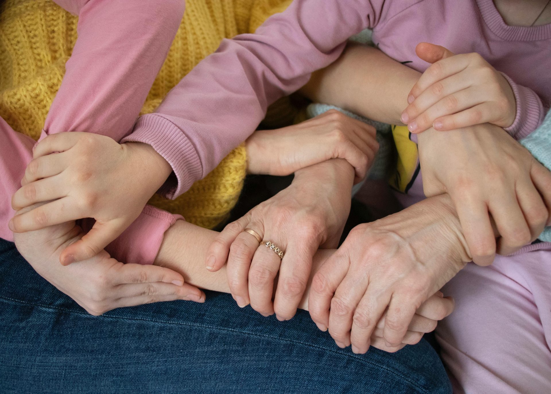 Múltiples brazos entrelazados, que simbolizan la unidad familiar y el apoyo entre generaciones.